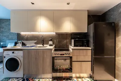 a kitchen with a refrigerator and a dishwasher at HAVN - Modern Studio in JVC with Huge Layout in Dubai