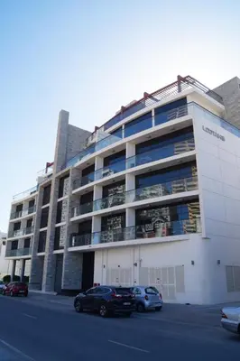 a large building with cars parked in front of it at HAVN - Modern Studio in JVC with Huge Layout in Dubai