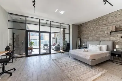 a bedroom with a bed and a brick wall at HAVN - Modern Studio in JVC with Huge Layout in Dubai
