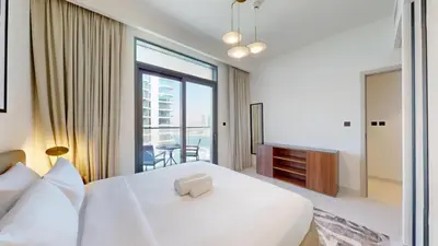 a bedroom with a white bed and a large window at Marina Vista - Airy One Bedroom in Dubai Marina in Dubai