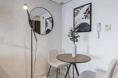a dining room with a table and a mirror at Lake View Studio near Marina with Pool, Sauna and Gym in Dubai