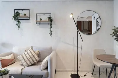 a living room with a couch and a mirror at Lake View Studio near Marina with Pool, Sauna and Gym in Dubai