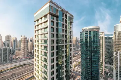 a tall white building in a city with buildings at Lake View Studio near Marina with Pool, Sauna and Gym in Dubai
