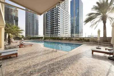 a swimming pool in the middle of a building with tall buildings at Lake View Studio near Marina with Pool, Balcony and Gym in Dubai