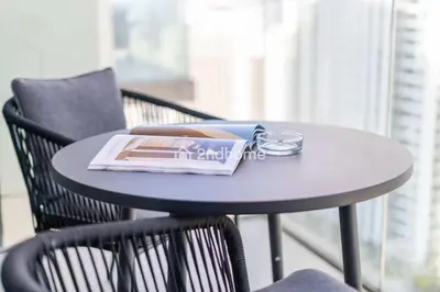a round table with a magazine and glasses on it at Luxurious Furnishing Direct Access to Dubai Mall in Dubai