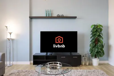 a living room with a tv with the indium logo on it at Livbnb - Spacious 2B in Shams with Marina View Walk to Beach in Dubai