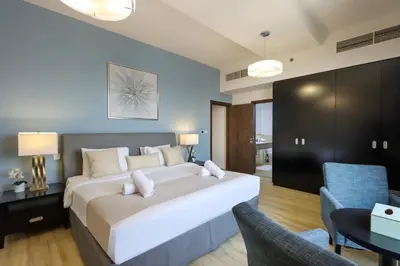 a bedroom with a large bed and two chairs at Livbnb - Spacious 2B in Shams with Marina View Walk to Beach in Dubai