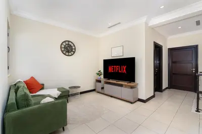 a living room with a couch and a tv at Samaya Holiday Homes - Luxury Villa Pool - Beach Access & Fishing Zone in Dubai