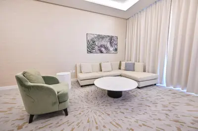 a living room with a couch and a table at Stylish 1-BR Retreat with Sweeping Views in Palm Tower in Dubai