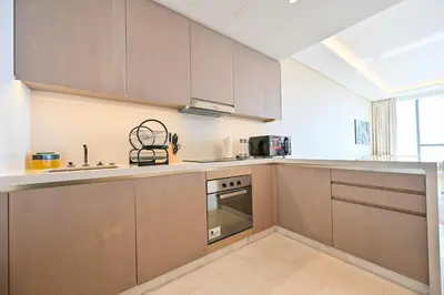a kitchen with wooden cabinets and a sink and a stove at Stylish 1-BR Retreat with Sweeping Views in Palm Tower in Dubai