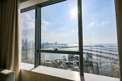 a view of the city from a hotel room window at Stylish 1-BR Retreat with Sweeping Views in Palm Tower in Dubai