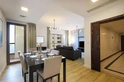 a dining room and living room with a table and chairs at Livbnb- Coastal 2B with Marina View Walk to Beach in Dubai