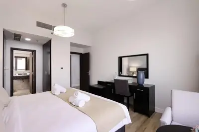 a bedroom with a bed and a desk and a tv at Livbnb - High Floor 2B with Marina View Walk to Beach in Dubai