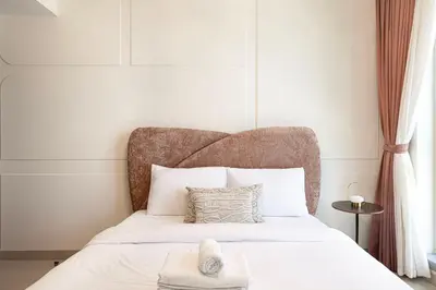 a bedroom with a white bed with a large headboard at Splendid 2BR Burj Khalifa & Fountain view in Dubai