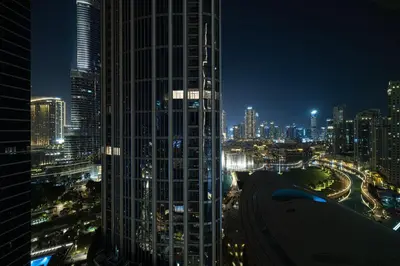 a city skyline at night with a tall building at Splendid 2BR Burj Khalifa & Fountain view in Dubai