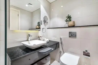 a white bathroom with a sink and a toilet at GuestReady - Luxe Comfort in Bussiness Bay in Dubai