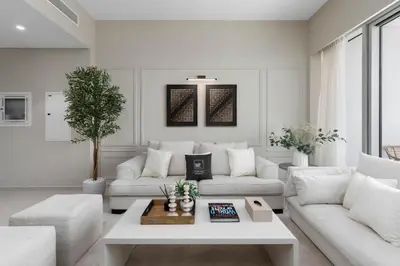 a living room with white furniture and a table at Maison Privee - Sky-High Elegance with Unrivaled Burj Khalifa Views in Dubai