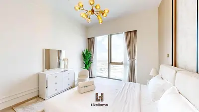 a white bedroom with a bed and a chandelier at Enjoy Best Burj Khalifa & Fountain Views From Balcony Luxury 2BR 3 Mins from Dubai Mall - Like Home in Dubai