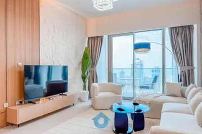 a living room with a couch and a tv at Steps from Dubai Mall Enjoy Dubai Skyline from Balcony Luxury 2 Bedroom Like Home in Dubai