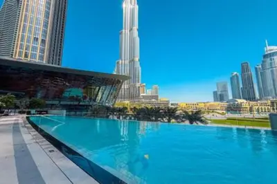 a large swimming pool in a city with tall buildings at Next to Burj Khalifa & Dubai Mall - Enjoy Dubai Skyline Luxury 2BR Like Home in Dubai