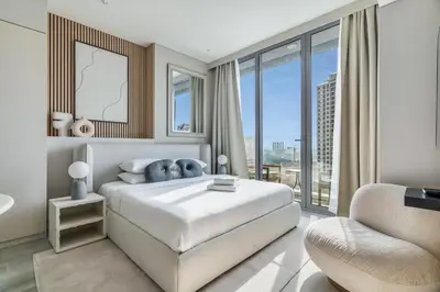 a bedroom with a large bed and a chair at GuestReady - Luxe Residence in Dubai Marina in Dubai