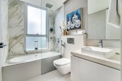a bathroom with a toilet and a sink and a tub at GuestReady - Luxe Residence in Dubai Marina in Dubai
