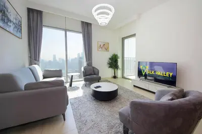 a living room with a couch and a tv at Silk Valley - Luxury 2B with iconic Burj Khalifa views and walk to Dubai Mall in Dubai