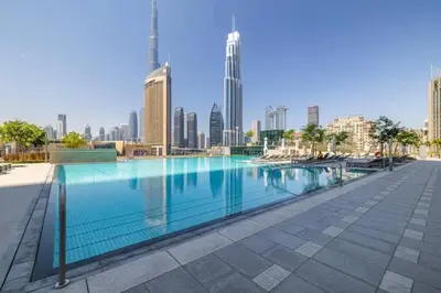a swimming pool with a city skyline in the background at Silk Valley - Luxury 2B with iconic Burj Khalifa views and walk to Dubai Mall in Dubai