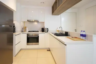 a kitchen with white cabinets and a stainless steel refrigerator at Silk Valley - Luxury 2B with iconic Burj Khalifa views and walk to Dubai Mall in Dubai