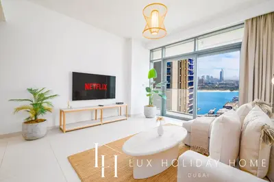 a living room with a couch and a tv at LUX The Beach Vista Dubai Eye View Suite in Dubai