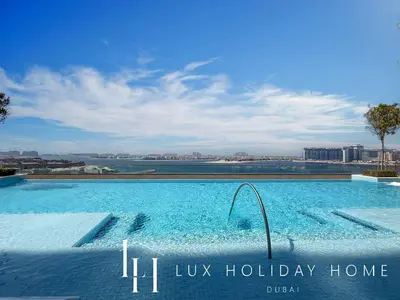 a large swimming pool with a view of the water at LUX The Beach Vista Dubai Eye View Suite in Dubai