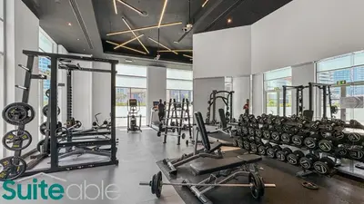 a gym with a lot of treadmills and machines at Spacious refurbished Studio steps away from metro in Dubai
