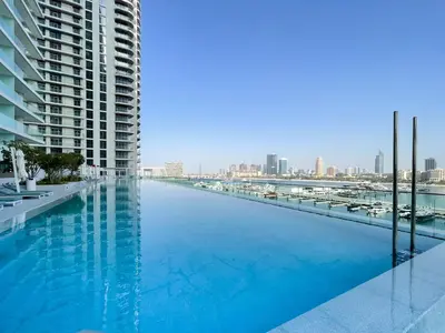 a large swimming pool with a view of a city at Breathtaking Elegance 1Bedroom in Emaar Beachfront in Dubai