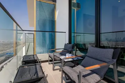 two chairs and a table in a room with windows at Luxury 1BR at Binghatti Onyx JVC in Dubai