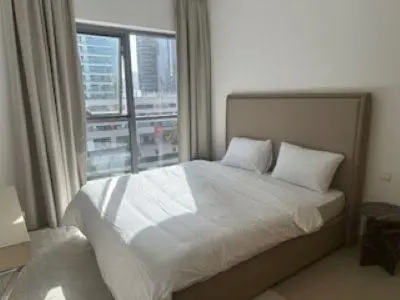 a bedroom with a bed and a large window at Hideaway in Downtown in Dubai