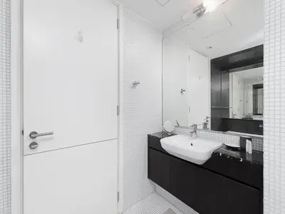a white bathroom with a sink and a mirror at Short stay Limestone House DIFC 2 bedrooms in Dubai