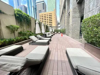 a row of chaise lounges and umbrellas on a patio in at Short stay Limestone House DIFC 2 bedrooms in Dubai