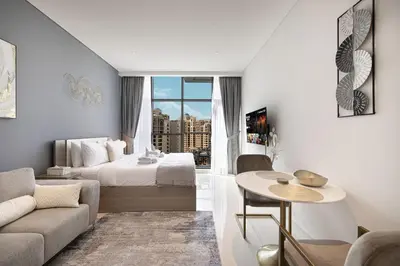 a bedroom with a bed and a living room at Seven Palm Apartment with Private Beach Access and Infinity Pool in Dubai
