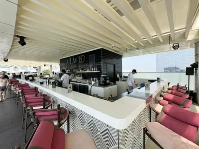 a restaurant with a bar with red chairs at Seven Palm Apartment with Private Beach Access and Infinity Pool in Dubai