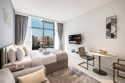 a hotel room with a bed and a large window at Seven Palm Apartment with Private Beach Access and Infinity Pool in Dubai