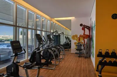 a gym with treadmills and ellipticals in a building at Private Apartment in Novotel JVT Comfort for 4 Guests in Dubai