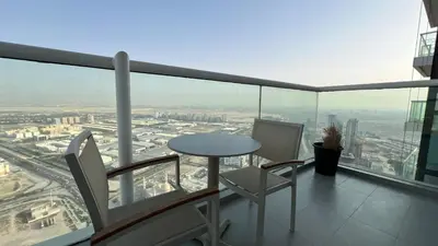 a balcony with a table and chairs on top of a building at Private Apartment in Novotel JVT Comfort for 4 Guests in Dubai