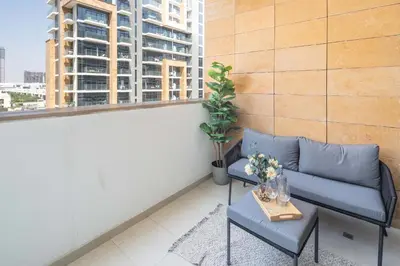 a balcony with a couch and a table and a window at Frank Porter - Azizi Riviera 26 in Dubai