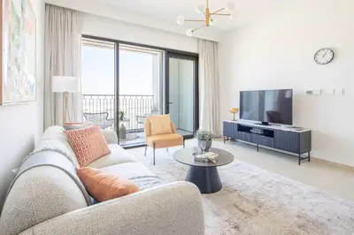 a living room with a couch and a tv at Frank Porter - Downtown Views II in Dubai