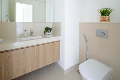 a bathroom with a sink and a toilet and a mirror at Frank Porter - Downtown Views II in Dubai