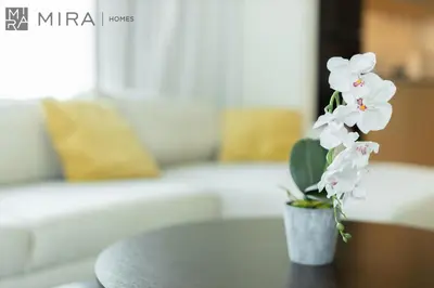 a vase with white flowers sitting on a table at Mira Holiday Homes - Cosy 1BHK in the heart of Dubai Creek Harbour in Dubai