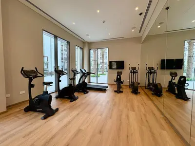 a gym with treadmills and exercise bikes in a room at FIRST CLASS 1BR Glamorous & Stylish Escape in Dubai