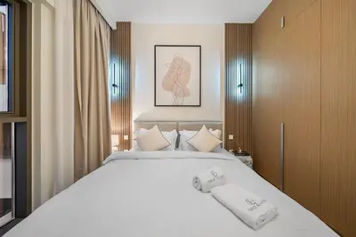 a bedroom with a large bed with two towels on it at FIRST CLASS 1BR Glamorous & Stylish Escape in Dubai
