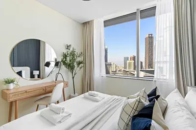 a bedroom with a bed and a desk and a window at Silkhaus Premium 1BR at Sky Gardens in Heart of DIFC in Dubai