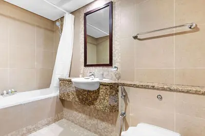 a bathroom with a sink and a toilet and a tub at Silkhaus Premium 1BR at Sky Gardens in Heart of DIFC in Dubai